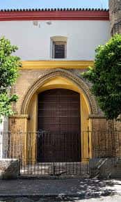 Puerta principal de la iglesia con arco de herradura y detalles en ladrillo y piedra