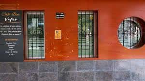 Fachada exterior del Bar Vafer con paredes naranjas y ventanales con rejas