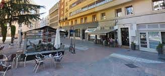 Vista exterior de la cafetería El Pregón con mesas al aire libre y ambiente urbano