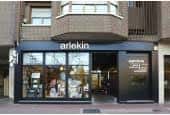 Entrada principal de la Librería Arlekin con vitrina iluminada y señalización clara