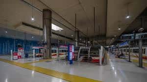 Plataforma de la estación con trenes modernos y señalización clara