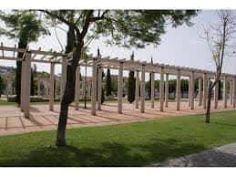 Pérgola de madera en el Parque de Manuel Navarrete con césped y árboles