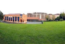 Vista exterior del Colegio Virgen Mediadora con fachada naranja y amplios jardines