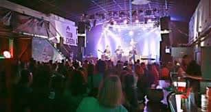 Banda actuando en el escenario con iluminación de concierto