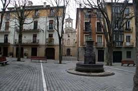 Plaza de San José con bancos, árboles sin hojas y fachadas tradicionales de Pamplona