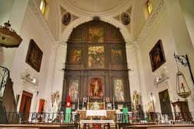 Interior de la iglesia con retablo mayor, altar y decoración religiosa