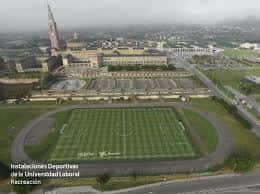 Instalaciones deportivas de la Universidad Laboral con pista de atletismo y campo de fútbol en primer plano
