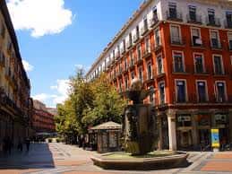 Vista diurna de la Calle Ferrari en Valladolid con fuente central y edificios históricos