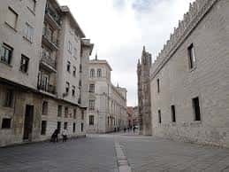 Perspectiva de la calle empedrada con el muro del monasterio a la derecha
