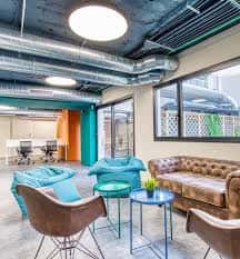 Zona de descanso con sofás y mobiliario moderno en Moasis Cowork
