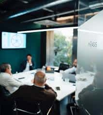 Sala de reuniones con pantalla y participantes en sesión