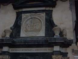 Detalle del escudo y la inscripción de la Sociedad Económica de Amigos del País en la fachada del edificio