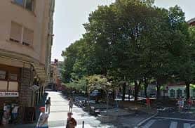 Plaza de Aldave con árboles frondosos y peatones en un día soleado