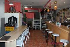 Interior del bar La Lokala con barra de madera y taburetes