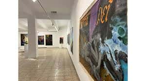 Vista del interior de la galería con obras de arte en las paredes