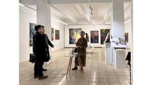 Escena de la galería con personas interactuando en el evento