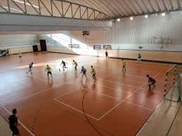 Actividad deportiva en el interior del polideportivo con jugadores en cancha