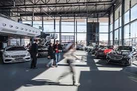 Interior del showroom con vehículos expuestos y clientes