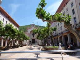 Plaza frente a la Parroquia de San Ignacio de Loyola con árboles y personas
