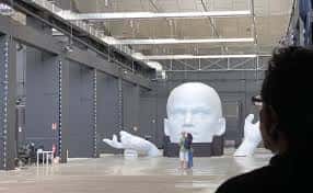Interior del espacio Sohrlin con escultura de cabeza gigante y visitantes