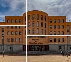 Vista frontal de la Facultad de Filosofía y Letras con fachada naranja y entrada principal