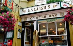 Fachada del Oyster Bar de English's con letrero clásico y flores colgantes