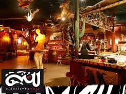 Interior del bar El Desierto Rojo con decoración temática de safari y luces cálidas