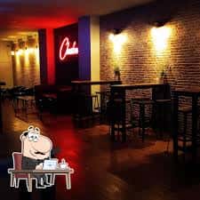 Interior del bar Chester con iluminación cálida y decoración de ladrillo