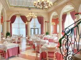 Salón de eventos interior con mesas dispuestas para banquete y decoración elegante