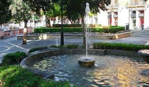 Fuente central de la Plaça de la Reina con jardines y bancos circundantes
