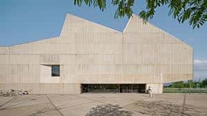 Vista exterior del Polideportivo Municipal de Altza con fachada de hormigón y diseño arquitectónico moderno