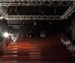 Interior del Teatro Alejandro Casona mostrando el escenario y las butacas rojas
