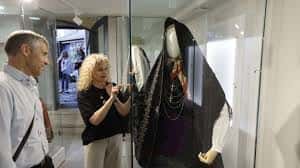 Interior del museo mostrando una exposición de vestimenta histórica en vitrina