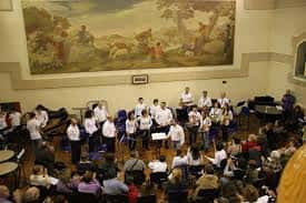 Interior del auditorio de La Galera durante una actuación musical con coro y público presente