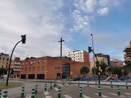 Vista exterior diurna de la Parroquia de Nuestra Señora de Fátima en Gijón, con fachada de ladrillo y cruz en la cúpula