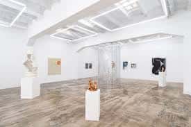 Interior de la Galería Fermay con obras de arte contemporáneo y suelo de madera clara
