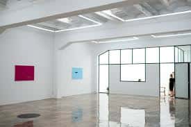 Espacio expositivo de la Galería Fermay con paredes blancas y grandes ventanales