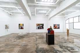 Sala de exposición en la Galería Fermay con esculturas y pinturas enmarcadas