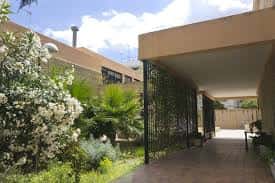 Paseo cubierto con vegetación y estructura arquitectónica del centro