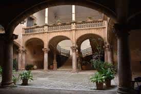 Vista del patio interior con arcos de piedra y escalera central