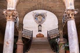 Escalera principal con escudo heráldico y columnas ornamentadas