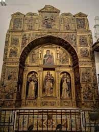 Altar mayor con retablo dorado y figuras religiosas