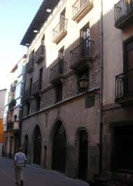 Vista exterior de la Casa del Cordón en Vitoria, mostrando su fachada histórica con arcos góticos y balcones de hierro