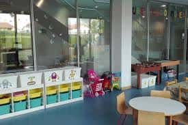 Interior de la zona infantil con estanterías de juguetes y mobiliario escolar