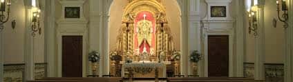 Interior de la capilla mostrando el altar principal con retablo dorado y decoración religiosa
