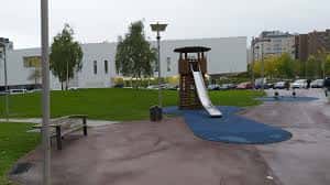 Zona de juegos infantiles con tobogán y superficie de seguridad