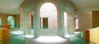 Espacio interior con arcos de piedra y vitrinas de exhibición