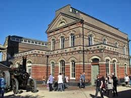 Fachada principal del British Engineerium con arquitectura victoriana y maquinaria histórica al frente