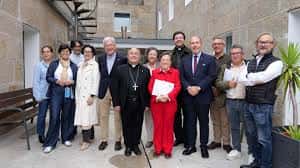 Grupo de personas reunidas en el patio interior del centro, incluyendo personal y representantes eclesiásticos