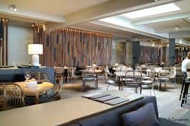 Interior moderno del restaurante con zona de comedor y decoración en tonos neutros